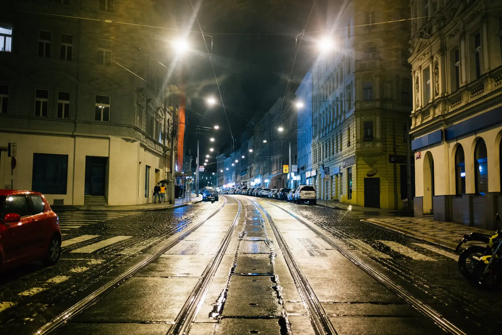 Tram tracks shining down a night street