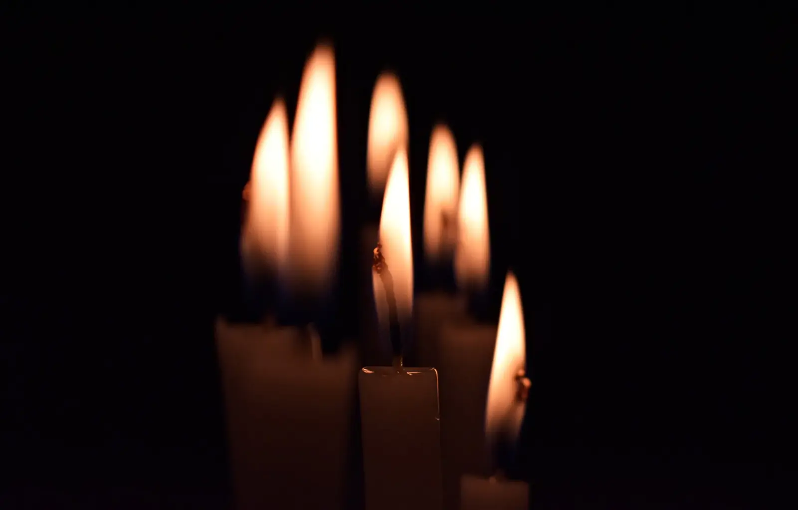 A cluster of candle flames in the dark