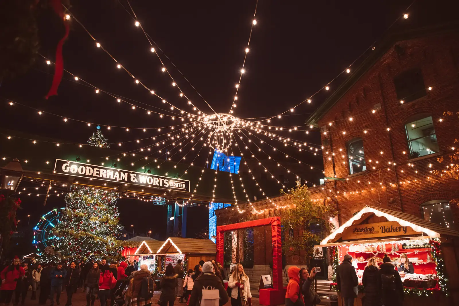 A winter market under canopies of string lights at night