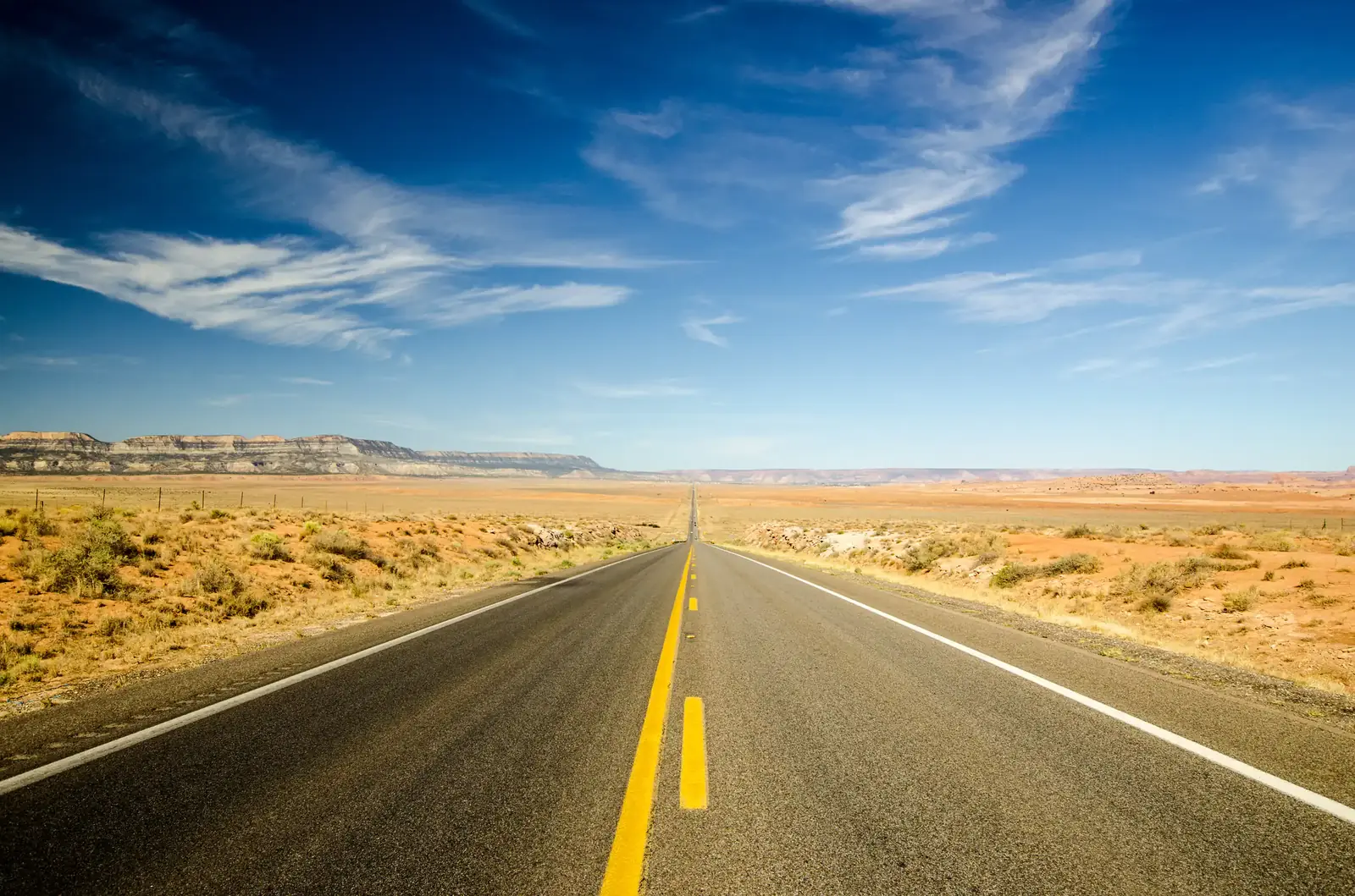 An open desert highway running to the horizon
