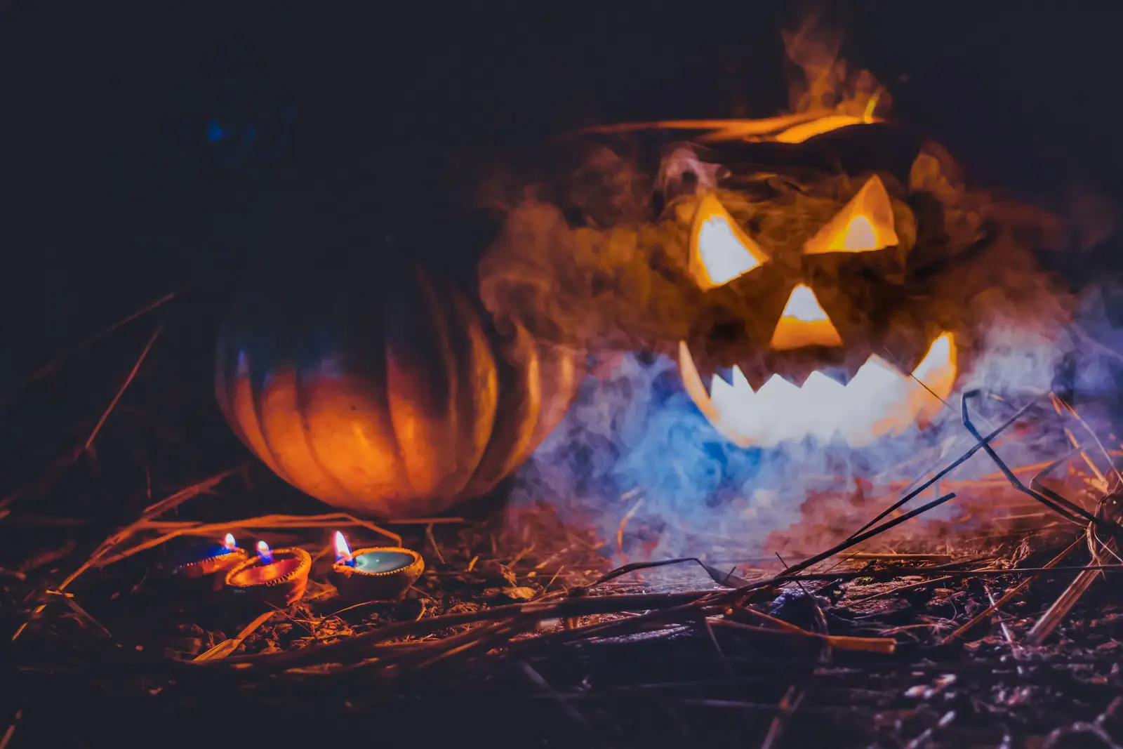A jack-o'-lantern glowing among embers and smoke
