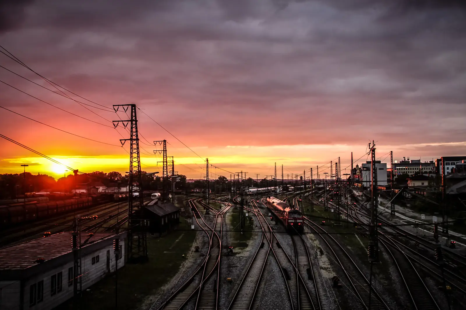 A fiery sunset over a busy rail yard