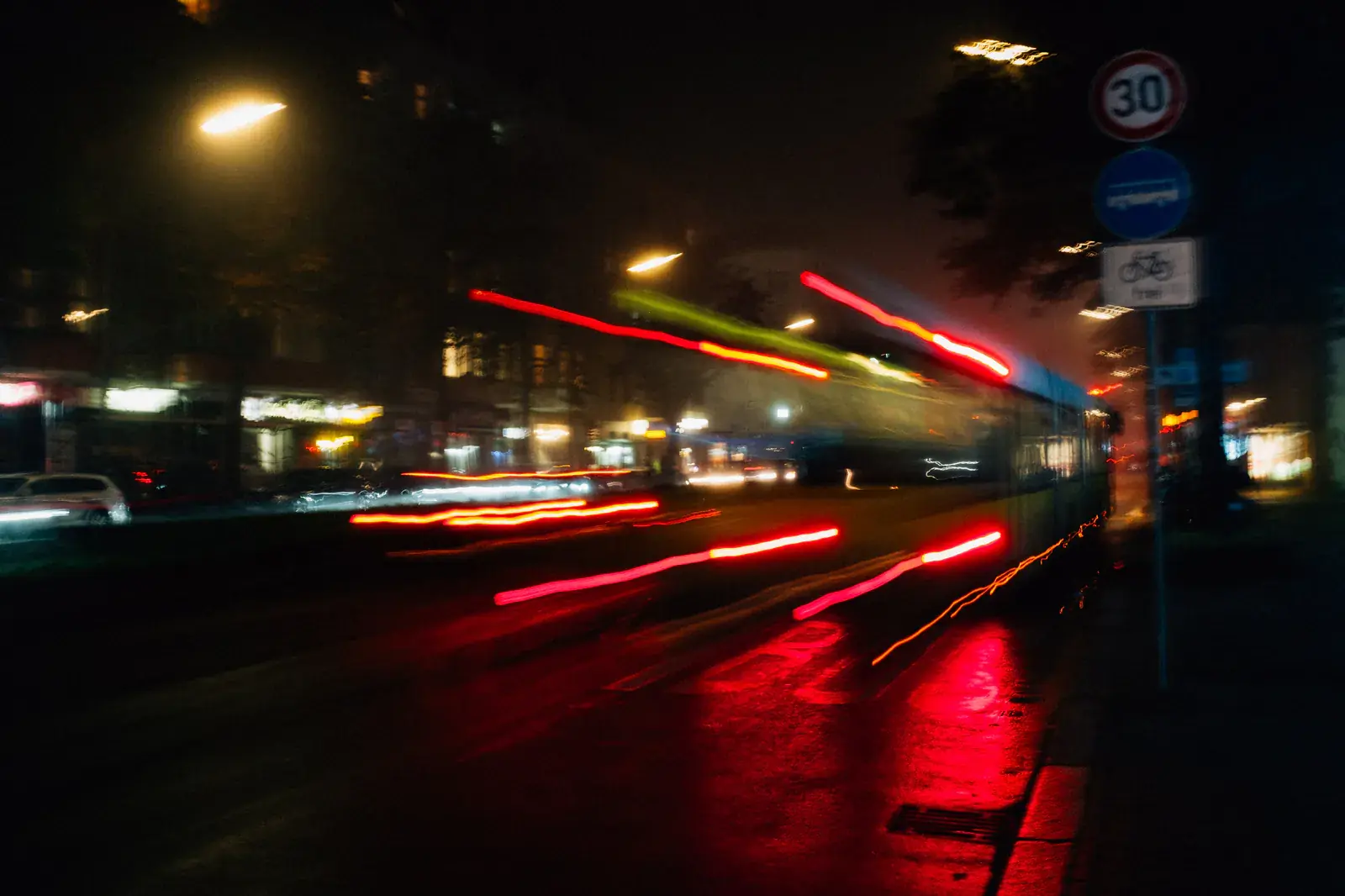 Red light trails streaking through a city street at night