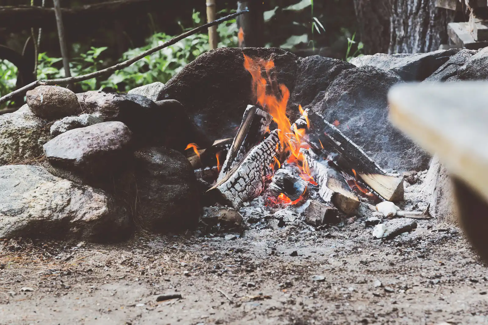 A campfire crackling among stones
