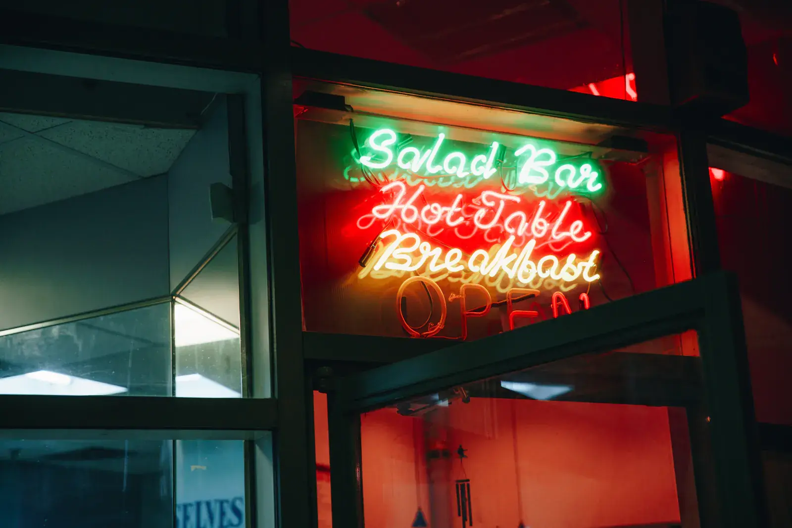 Red and green neon diner signs glowing in a window