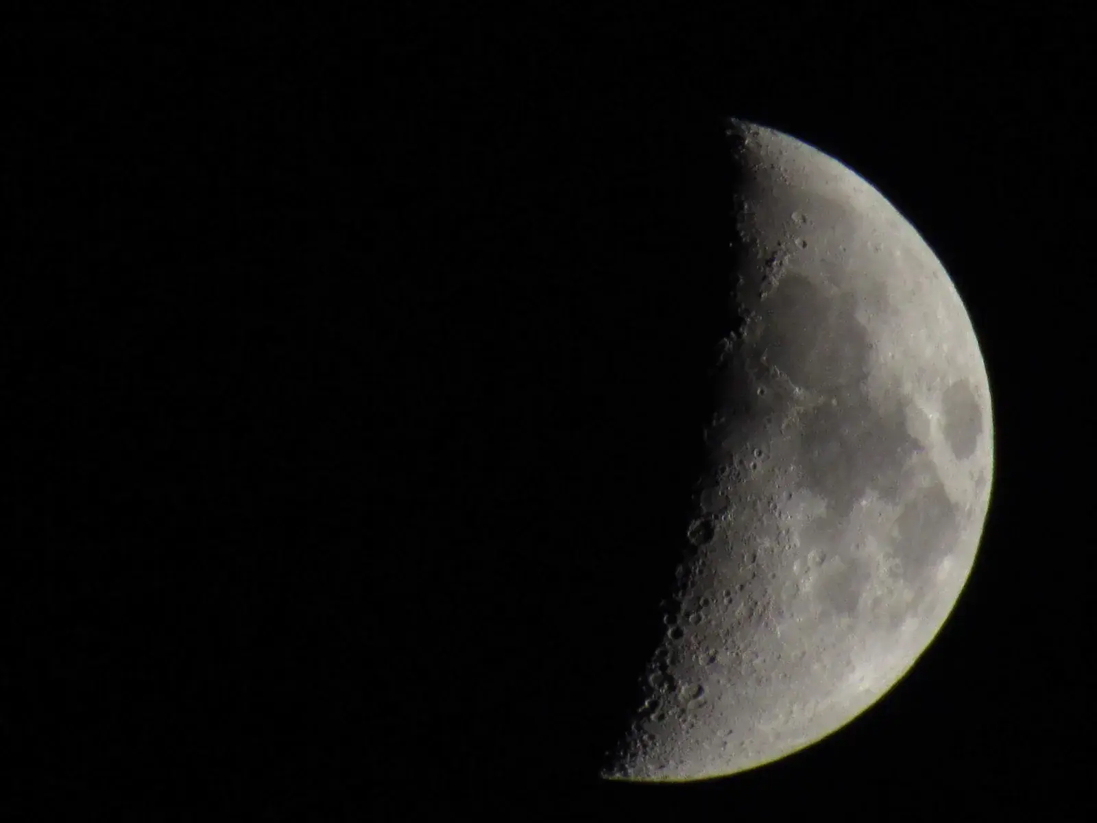 A sharp half Moon against black sky
