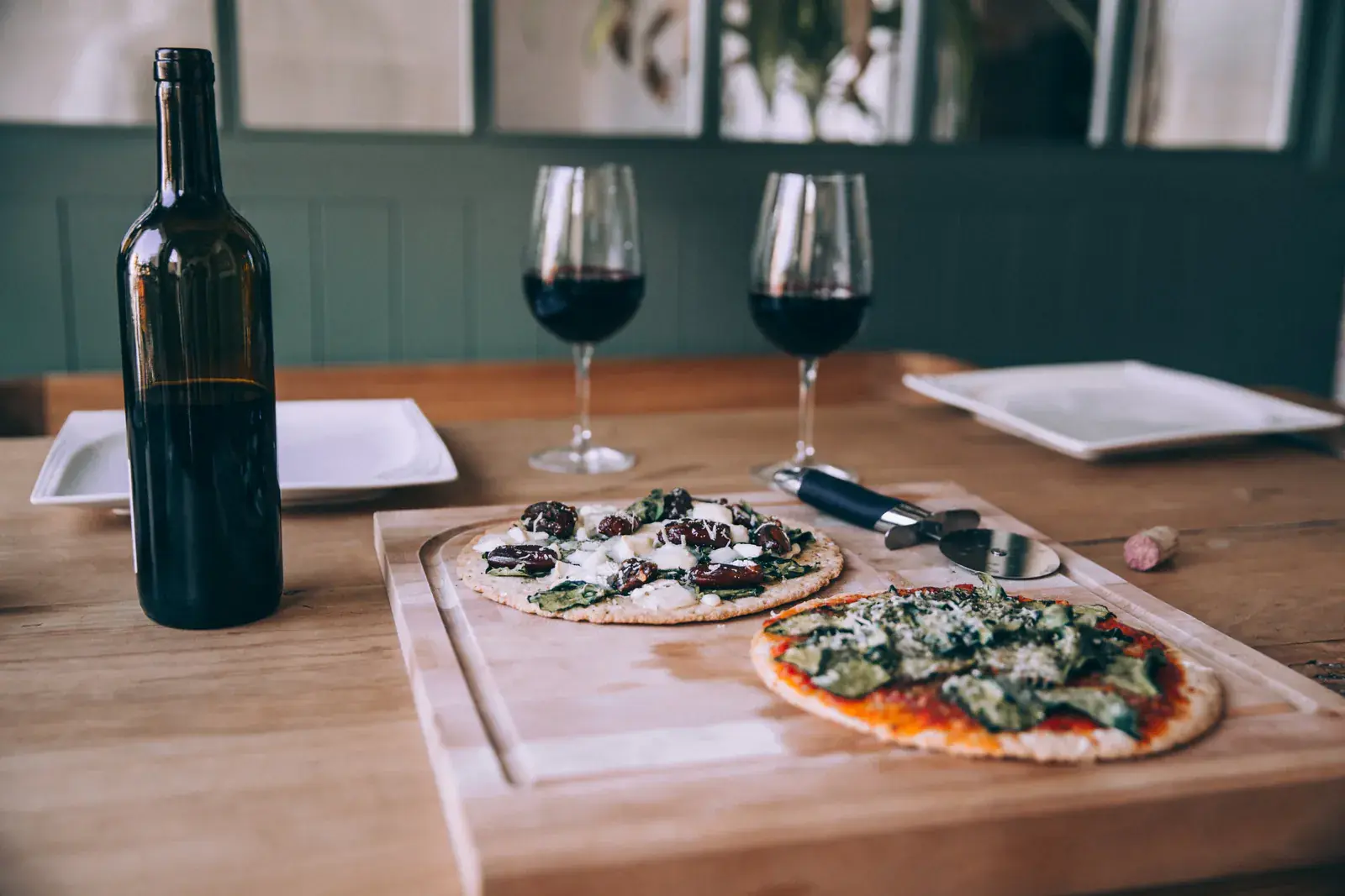 Wine glasses and a homemade pizza on a wooden table
