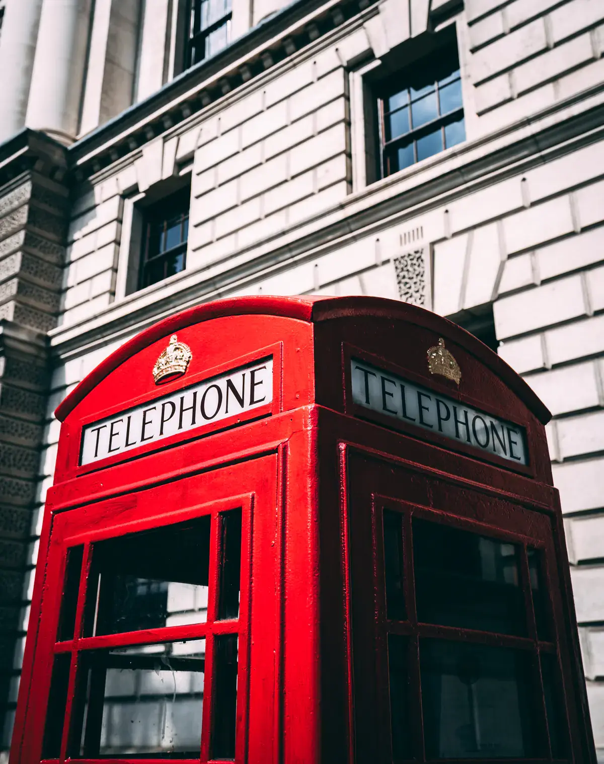 Two red telephone boxes on a city street