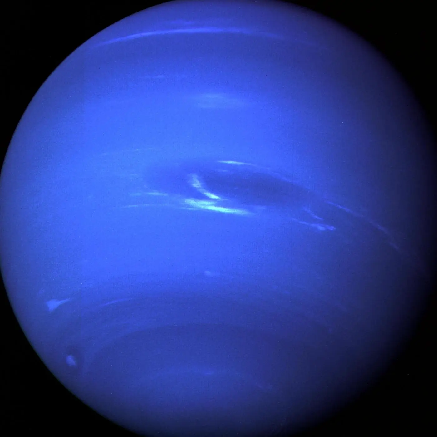 Neptune, a deep blue globe with bright high clouds, photographed by Voyager 2