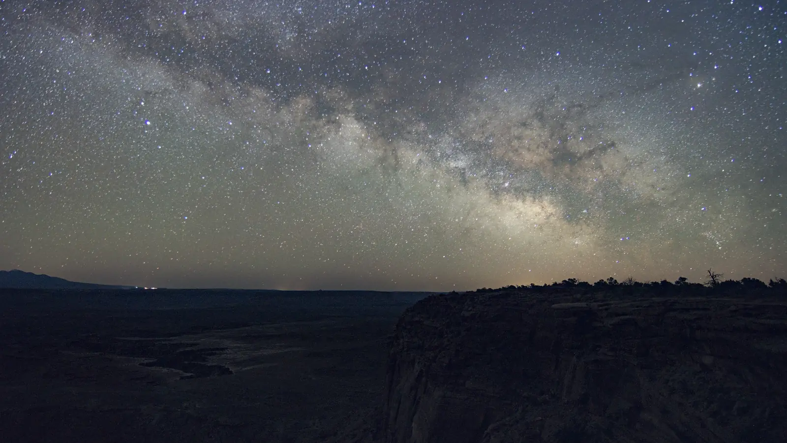 The Milky Way core rising over the dark rim of Buck Canyon
