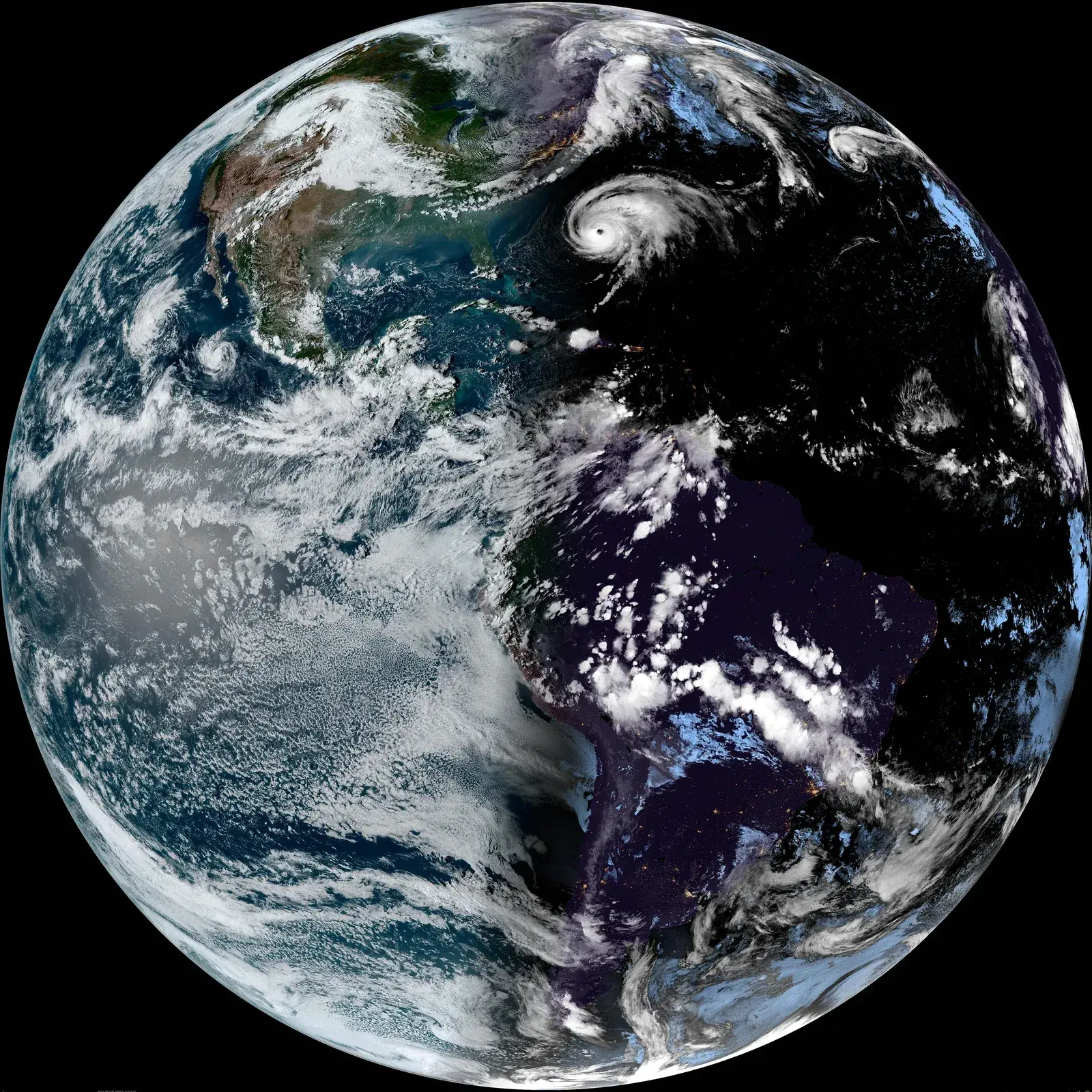 Full-disk satellite image of Earth over the Americas, the eastern half in night, the day-night line running pole to pole