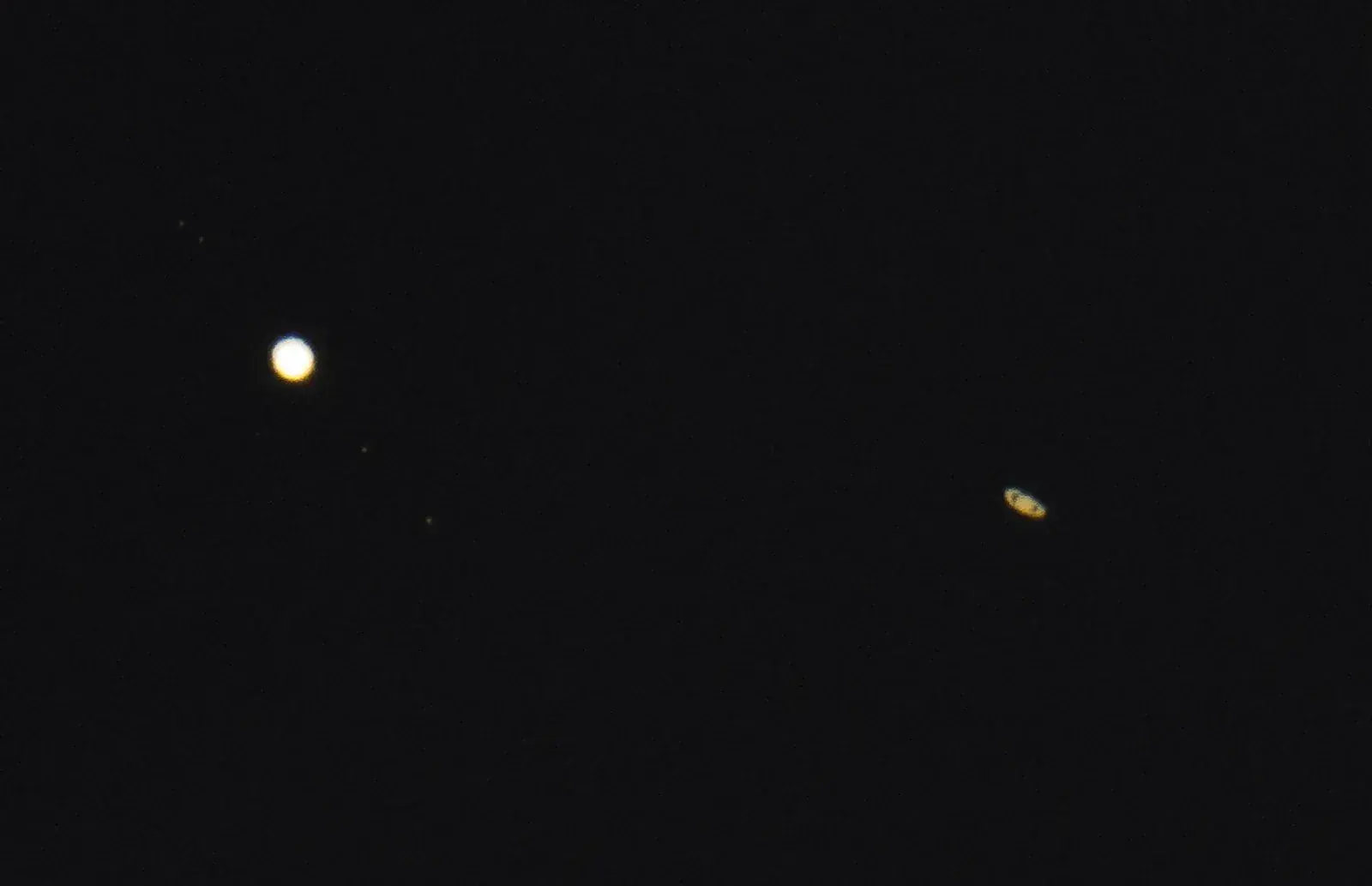 Telescopic photo of bright Jupiter at left and ringed Saturn lower right, set further apart than the night before