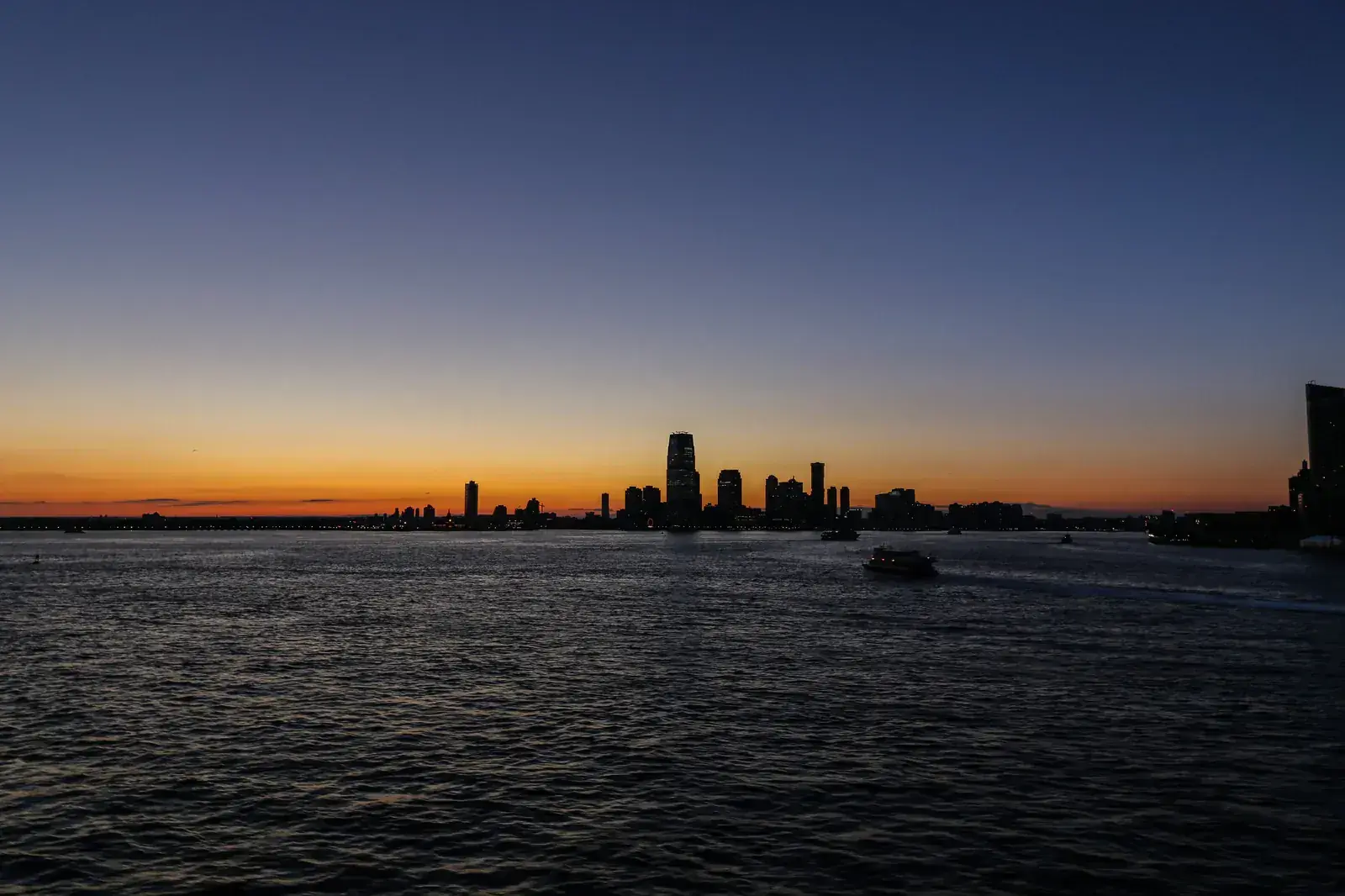 A city silhouette under a fading orange horizon