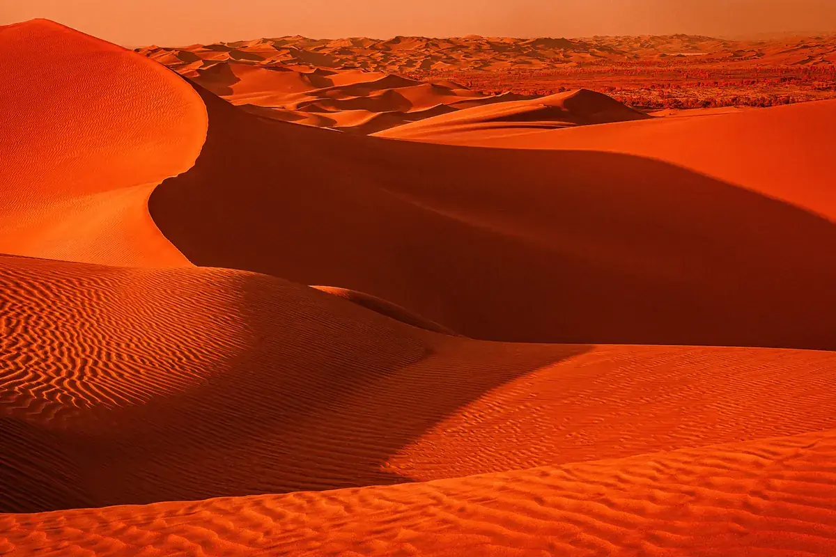 Red-orange desert dunes rippled by the wind (Leo and Virgo compatibility)