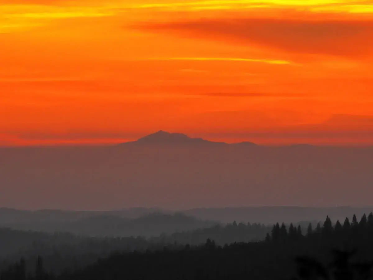 Mountain ridges in layers under a burning orange sunset (Aries and Virgo compatibility)