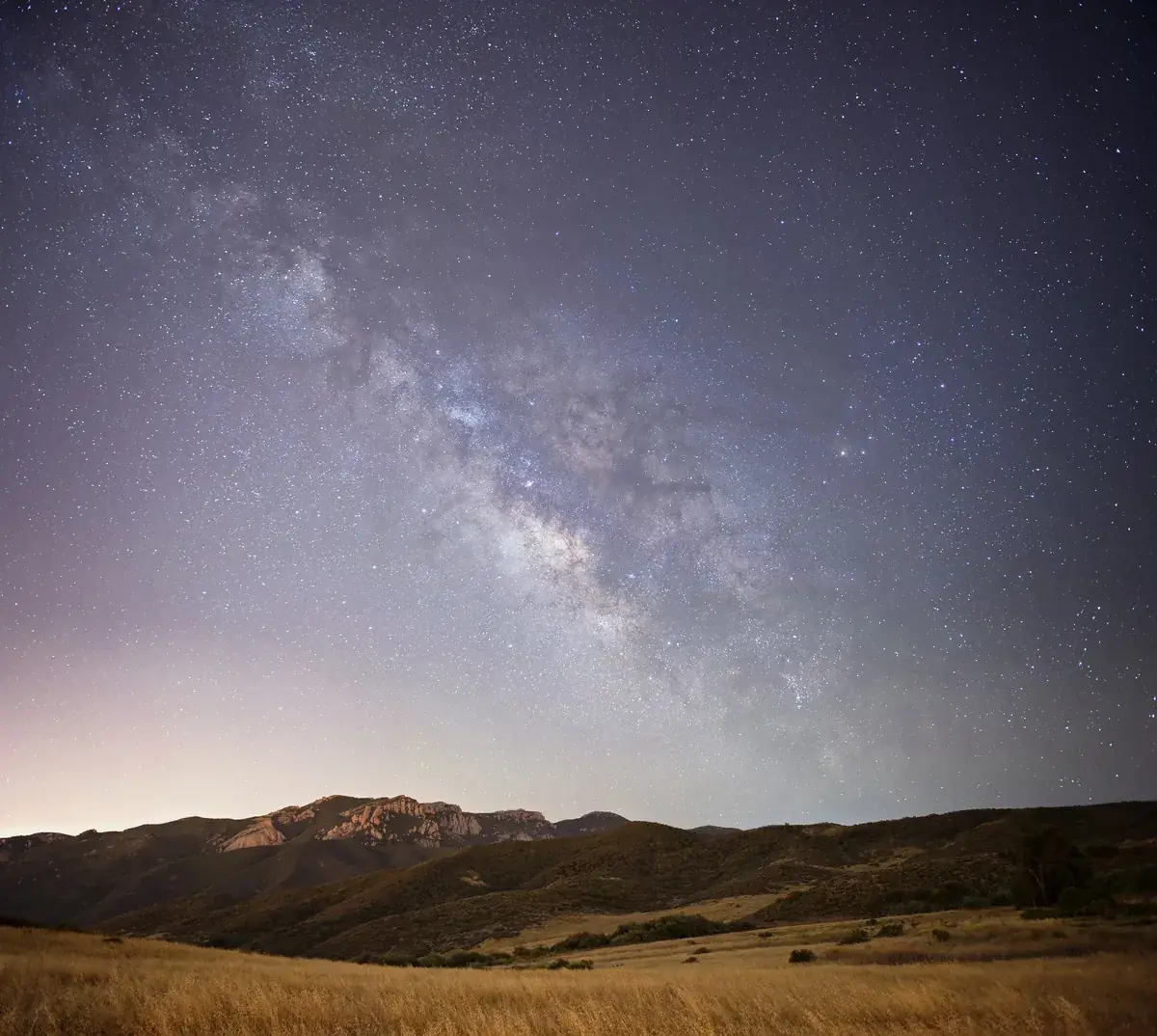The Milky Way over golden grassland and Boney Mountain