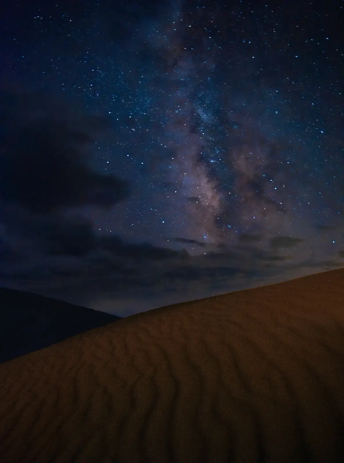 The Milky Way over wind-rippled sand dunes