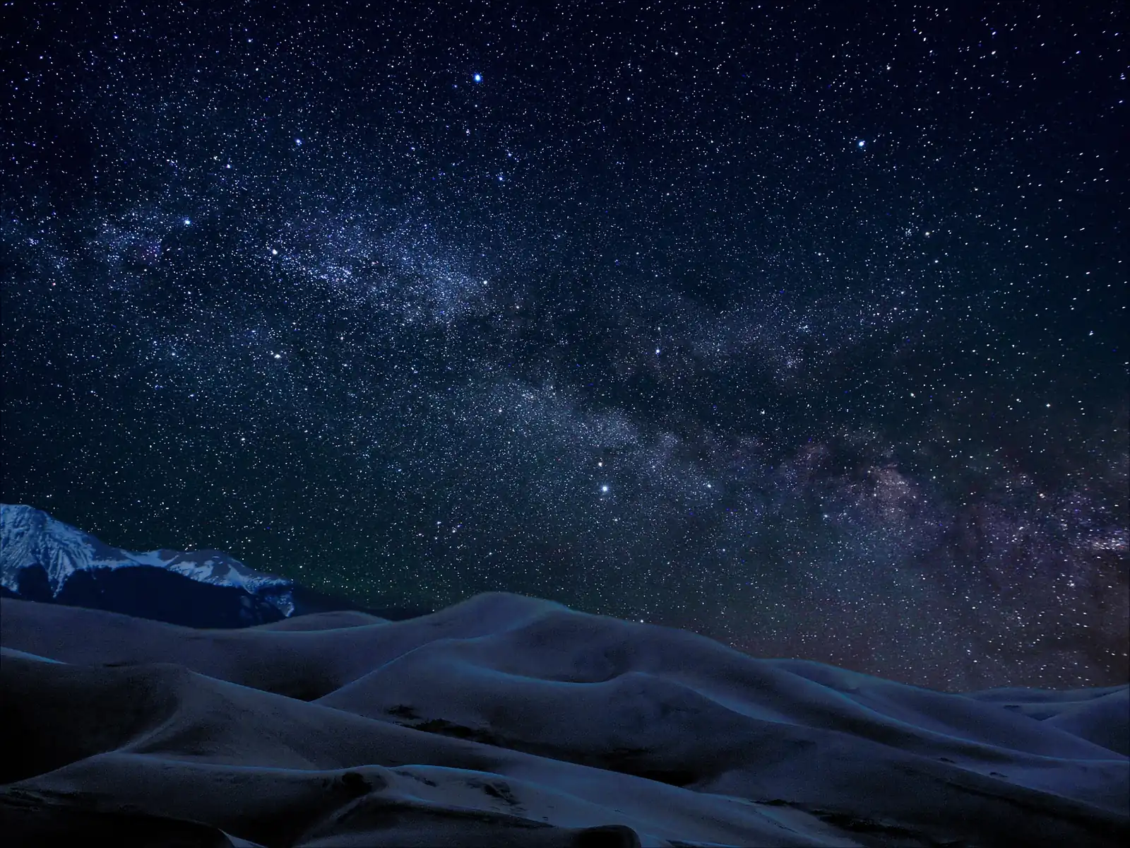 The Milky Way over moonlit sand dunes