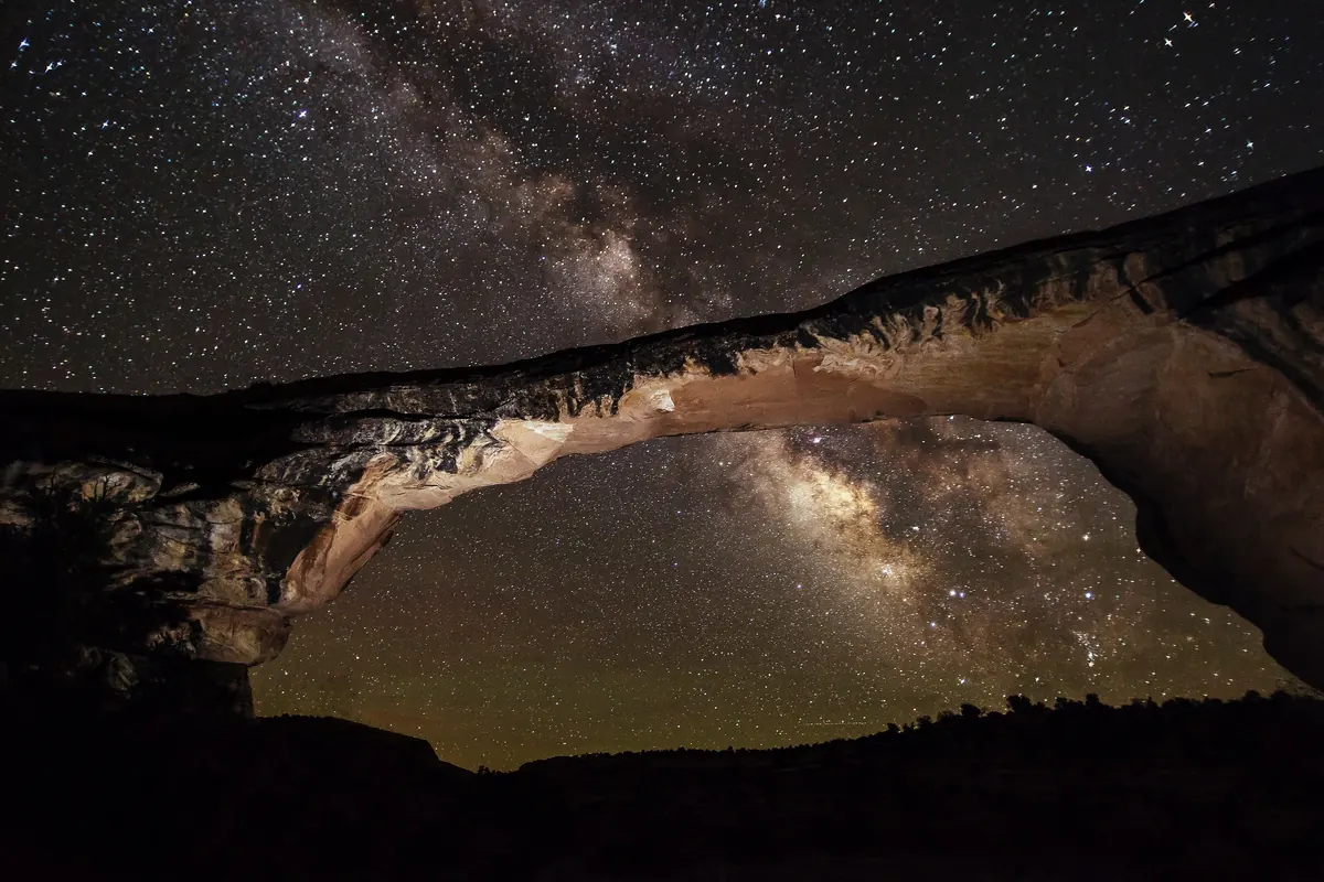 The Milky Way framed by the stone arch of Owachomo Bridge