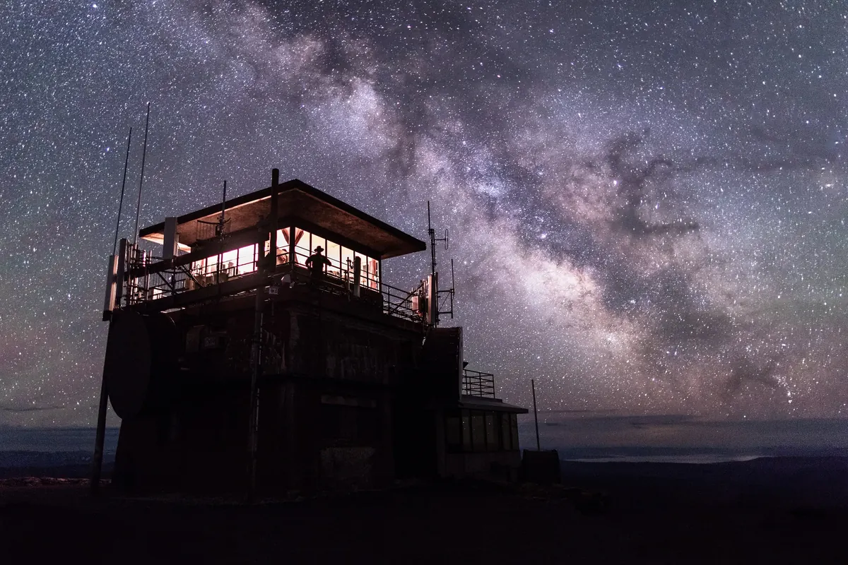 A mountaintop fire lookout under the Milky Way