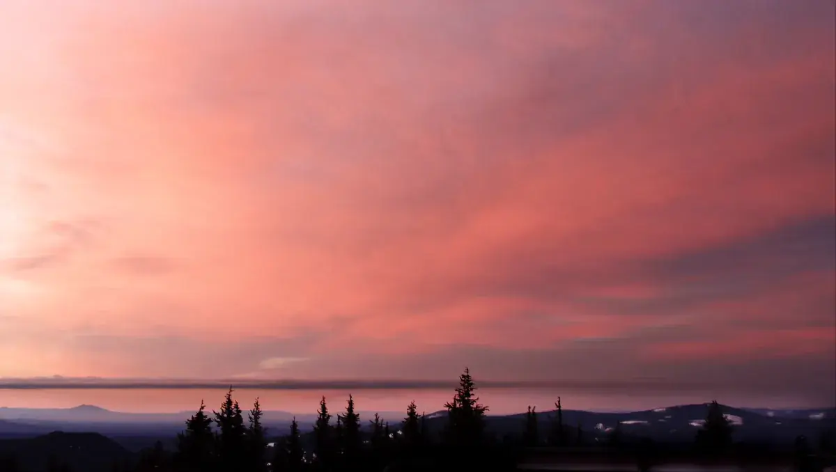 Coral-pink sunset clouds over a misty forested valley (Aries and Aquarius compatibility)